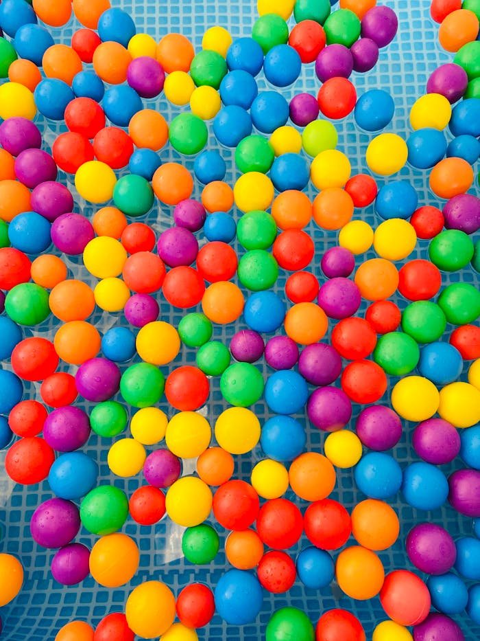 Colorful plastic balls floating on water, creating a playful and vibrant scene.